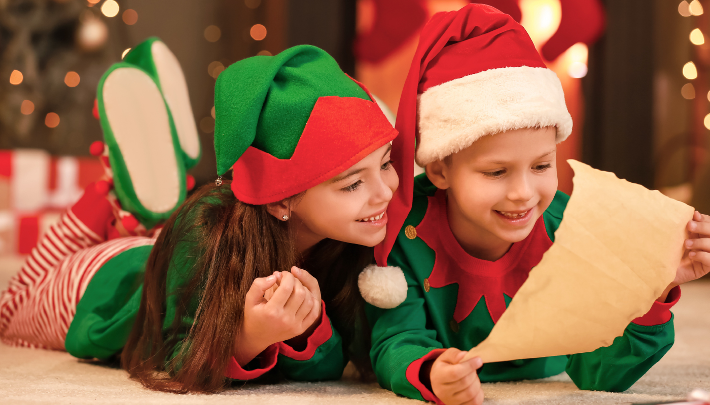 Bambini vestiti da elfi leggono una lettera a Babbo Natale